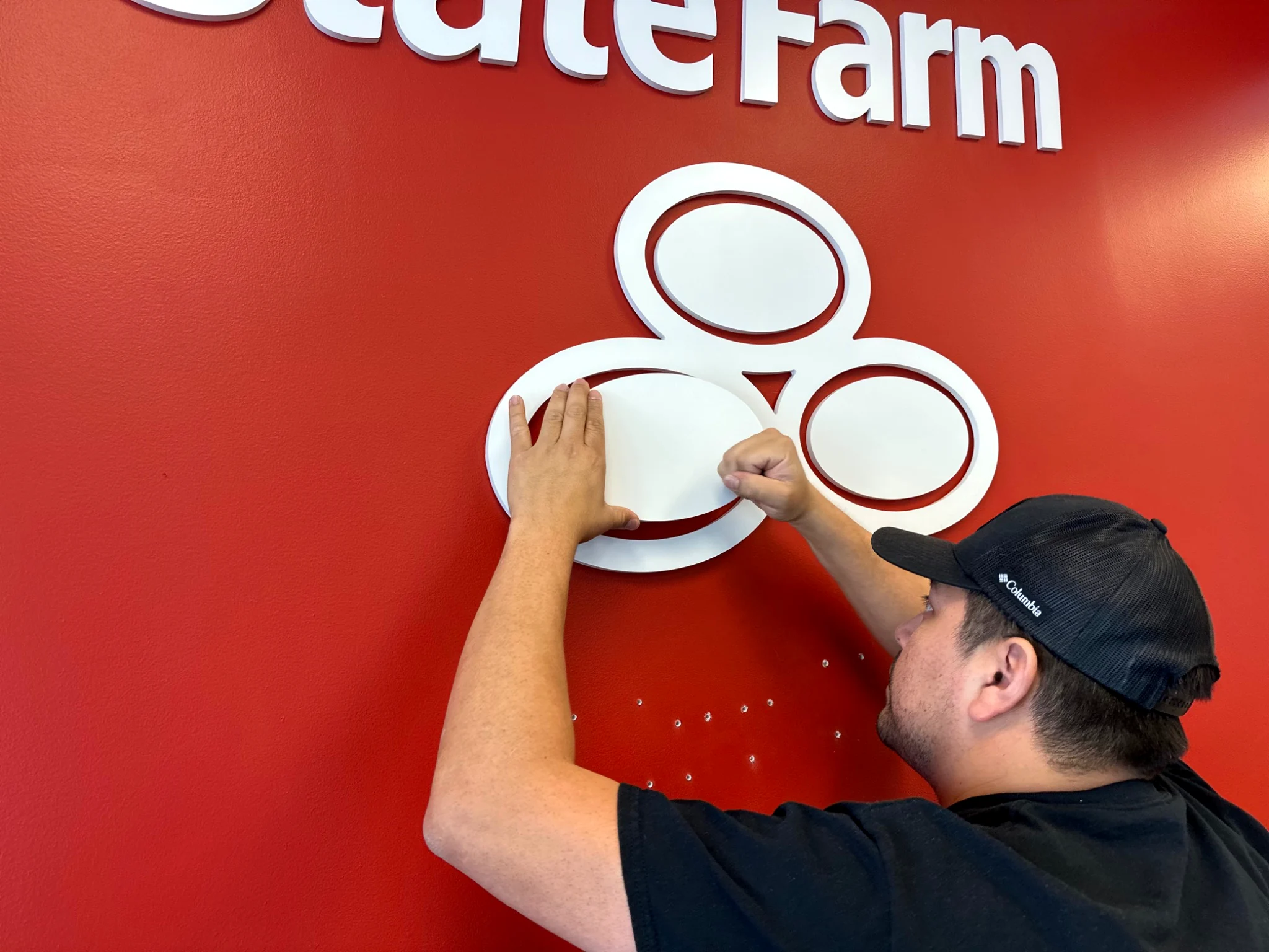 State Farm white dimensional lettering on a vivid red interior feature wall